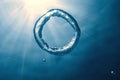 Bubble ring Underwater ascends towards the sun. Royalty Free Stock Photo