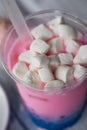 Bubble tea in pink and blue color in a plastic Cup with a straw. The top is sprinkled with marshmallows. Soft, beautiful Royalty Free Stock Photo