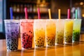 Bubble tea in various colors, variety of tapioca tea milkshake in a row.