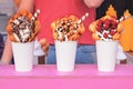 Bubble waffles with raspberries, chocolate and marshmallow in white paper cups are sold on food festival event. Royalty Free Stock Photo