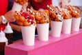 Bubble waffles with raspberries, chocolate and marshmallow in white paper cups are sold on Open kitchen food festival event. Royalty Free Stock Photo