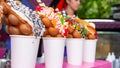 Bubble waffles with raspberries, chocolate and marshmallow in white paper cups are sold on Open kitchen food festival event. Hong Royalty Free Stock Photo
