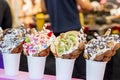 Bubble waffles with raspberries, chocolate and marshmallow in white paper cups are sold on Open kitchen food festival event. Royalty Free Stock Photo