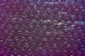 Bubble wrap packing on dark violet background Royalty Free Stock Photo