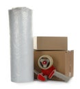 Bubble wrap roll, cardboard boxes and tape dispenser on white background Royalty Free Stock Photo