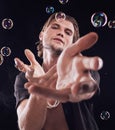 Bubbles, hands and man in studio for magic portrait, art performance and creative by black background. Alluring model