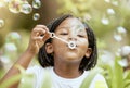 Bubbles, playful and African girl in nature with freedom, smile and playing in a park. Spring, happy and carefree child Royalty Free Stock Photo