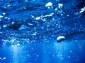 Bubbles from a Scuba diver rising to the surface in the blue sea