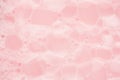 Bubbles of soap foam floating on pink water as abstract gentle background.