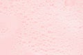 Bubbles of soap foam floating on pink water as abstract gentle background, copy space.
