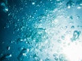 Bubbles and sun rays in underwater, in blue sea. Royalty Free Stock Photo