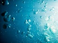 Bubbles in underwater. Sun light in blue ocean. Water texture. Royalty Free Stock Photo