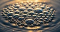 Bubbles of varying sizes cluster together on a liquid surface, reflecting light in golden Royalty Free Stock Photo