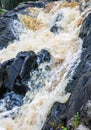 a bubbling fast cold river with cliffs and waterfalls, a mountain river with rapids Royalty Free Stock Photo