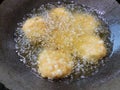 The bubbling oil surrounds each fritter, causing the crispy outer layer to form as they gently float in the pan. Royalty Free Stock Photo