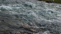 Bubbling water in a boisterous river in a mountainous area.