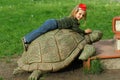 Bucha, Ukraine - 6 May, 2018: Book festival in the public park, toddler girl lying on a giant turtle climbing on a giant pile of b
