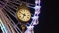 Bucharest Parliament public clock with Christmas ferris wheel in the back, at night. 1459 is engraved on the clock face.