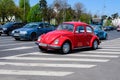 Bucharest, Romania, 24 April 2021 Old retro vivid red Volkswagen Beetle classic car in traffic in a street in a sunny spring day Royalty Free Stock Photo