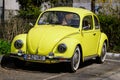 Bucharest, Romania, 2 April 2021 Old retro yellow Volkswagen Beetle classic car parked a street in a sunny spring day Royalty Free Stock Photo