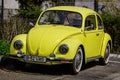 Bucharest, Romania, 2 April 2021 Old retro yellow Volkswagen Beetle classic car parked a street in a sunny spring day Royalty Free Stock Photo