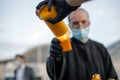 An orthodox christian priest with a surgical mask due to the covid-19 pandemic shares the Holy Light during the orthodox Easter Royalty Free Stock Photo