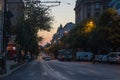 Cars and people at sunset.