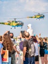 Crowd of people watching and taking pictures to a helicopter