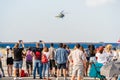 Crowd of people watching and taking pictures to a helicopter