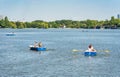 Many people in boats paddling on the lake in King Mihai I park (Herestrau). Couple on a