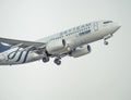 A TAROM BOEING 737-700 airplane flying against clear blue sky Royalty Free Stock Photo