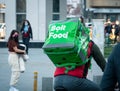 Bolt food courier on a bicycle carrying the green delivery bag. Young adult delivering the order