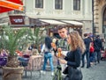 Busy weekend day with many people on the streets of old town center in Bucharest. Couple eating