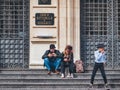 Costumed couple and a child in front of the National Romanian Bank in the old town center of