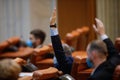 Romanian deputies vote bills by raising their hands in a full Chamber of Deputies meeting