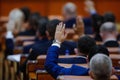 Romanian deputies vote bills by raising their hands in a full Chamber of Deputies meeting