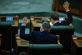 Romanian senators vote bills by raising their hands in a full Senate meeting