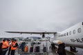 Luggage handlers taking care of the baggage of an ATR 72 that just landed in Bucharest Otopeni Henri Coanda Airport Royalty Free Stock Photo