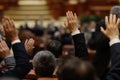 Shallow depth of field selective focus with details of Romanian MPs voting by raising their hands