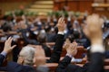 Shallow depth of field selective focus with details of Romanian MPs voting by raising their hands