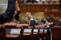 Shallow depth of field selective focus with details of Romanian MPs voting by raising their hands