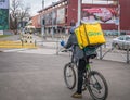 Glovo courier on a bicycle carrying the yellow delivery bag