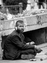 Bucharest/Romania - 07.25.2020: Homeless man or beggar sitting on the sidewalk and wearing headphones