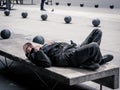Homeless man sleeping on a bench in the middle of the day , in Bucharest, Romania
