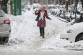Woman tries to walk through heavy snow during a winter day in Bucharest