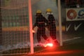 Firefighter tries to extinguish torches thrown on the grass