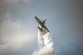 Bucharest, Romania - July 28, 2018: Stunt airplane during acrobatic flight. Smoke trace and clouds create a dramatic background