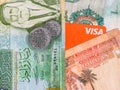 Macro detail picture with Jordanian dinar banknotes and a Visa credit or debit card. JOD is the