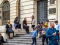 Many people in costumes sitting on the stairs in front of Romanian National Bank Banca Nationala