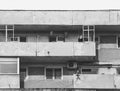 Isolated man smoking a cigar in a balcony of a worn out communist apartment building in Bucharest Royalty Free Stock Photo